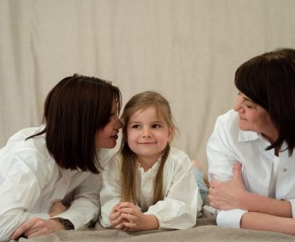 Three generations of women smiling together, symbolizing familial love and connection.